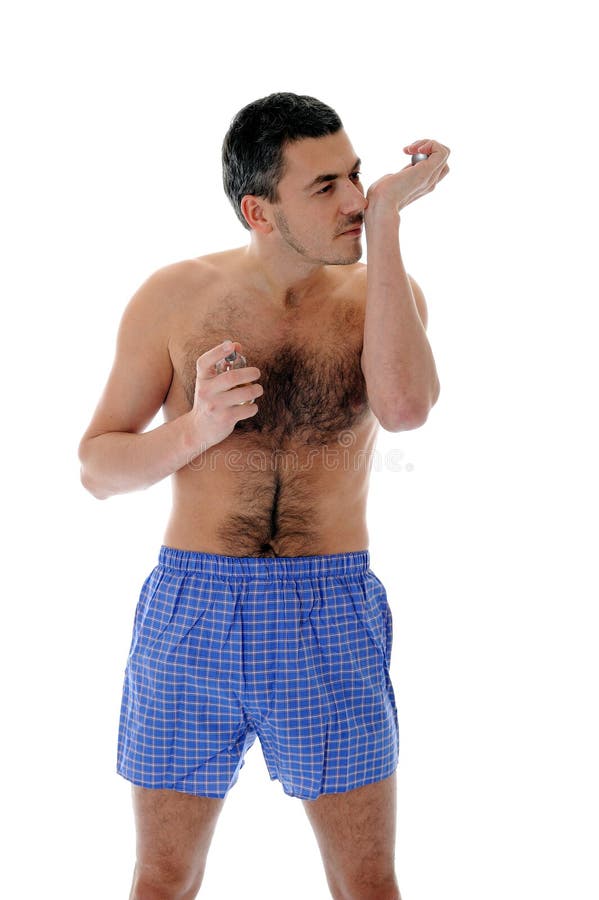 Handsome young male spray perfume on his skin royalty free stock image
