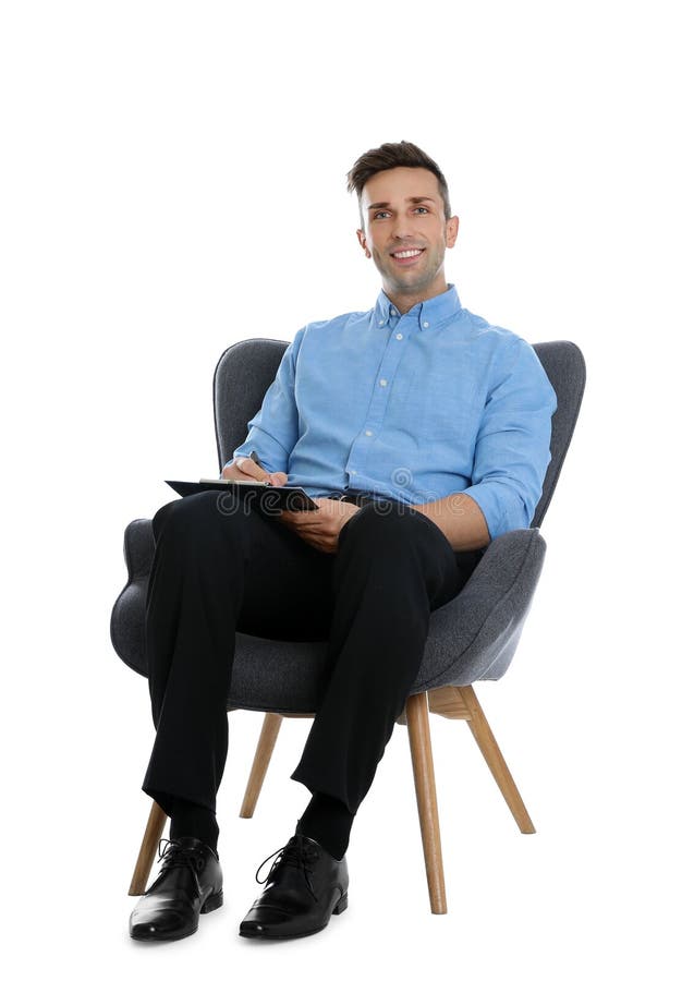 Handsome young man with clipboard sitting in armchair on background stock images Handsome young man with clipboard sitting in armchair on background stock images