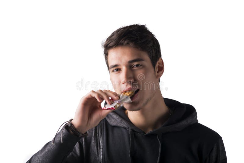 Handsome young man eating cereal bar, isolated stock image Handsome young man eating cereal bar, isolated stock image