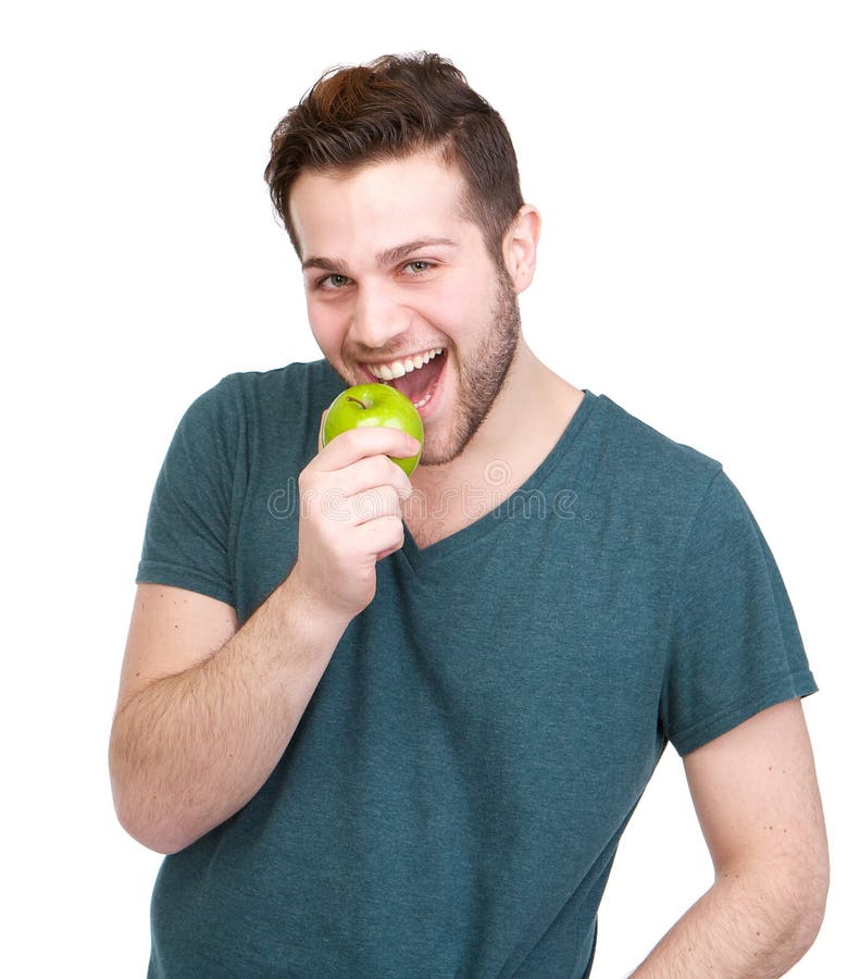 Handsome young man eating green apple stock photos