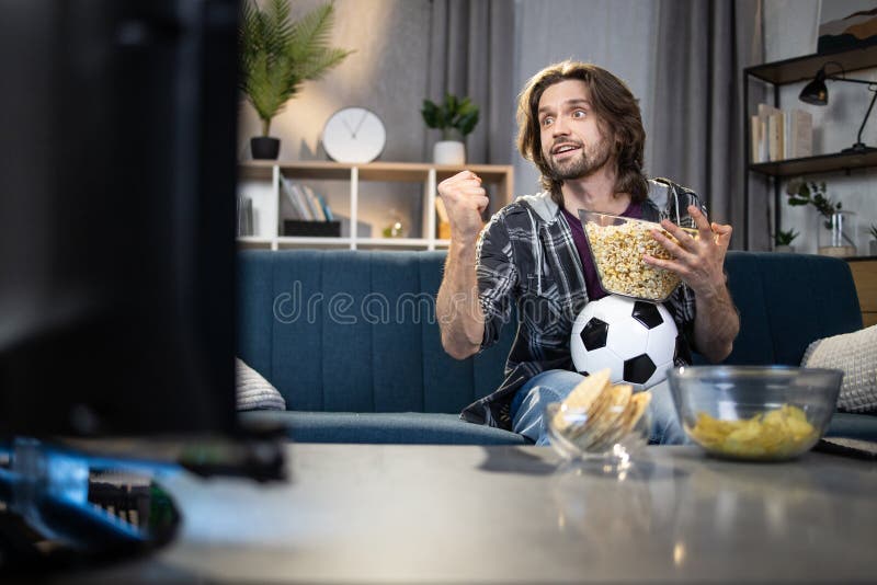 Handsome man enjoying football championship on TV