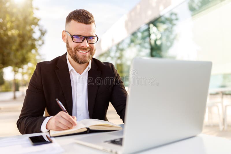 Carino uomo imprenditore possesso connesso a internet ascoltare accuratamente computer portatile al di fuori sul terrazza.