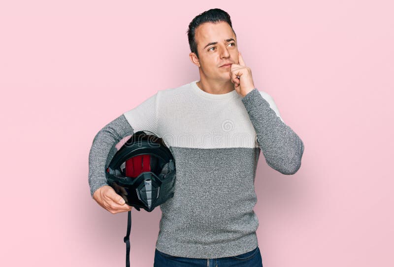 Handsome Young Man Holding Motorcycle Helmet Serious Face Thinking