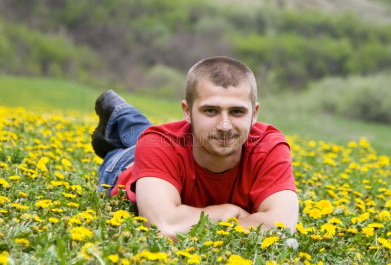 Handsome young man laying in a meadow