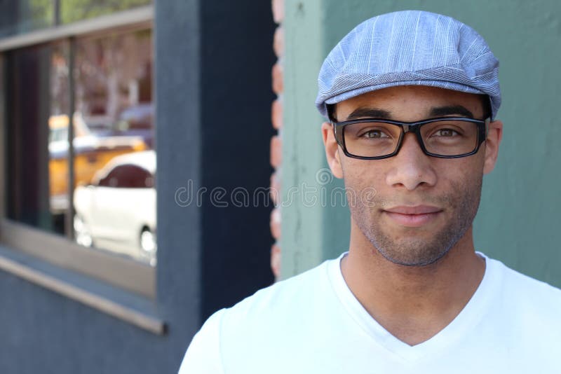 A handsome young man in plain clothes wearing hat and glasses royalty free stock photography A handsome young man in plain clothes wearing hat and glasses royalty free stock photography