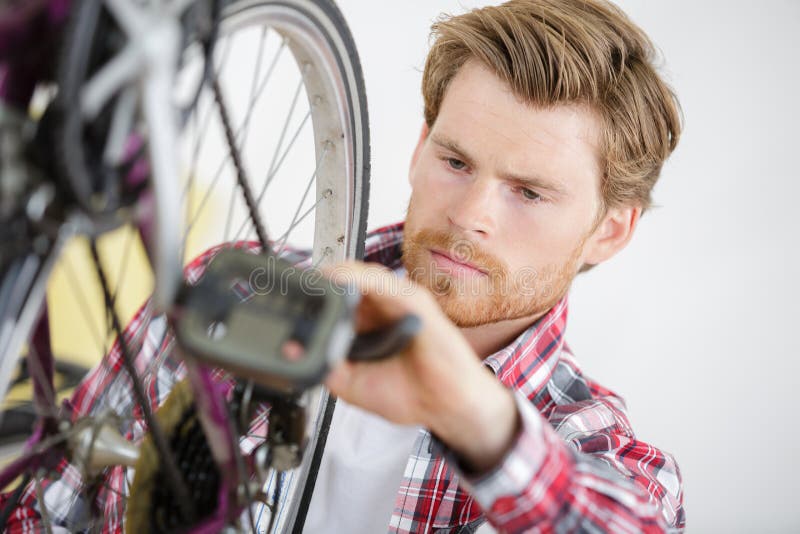 Handsome Young Man Repairing Bike Gear In Workshop