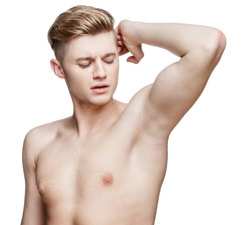 Handsome young man sniffing his armpit. 