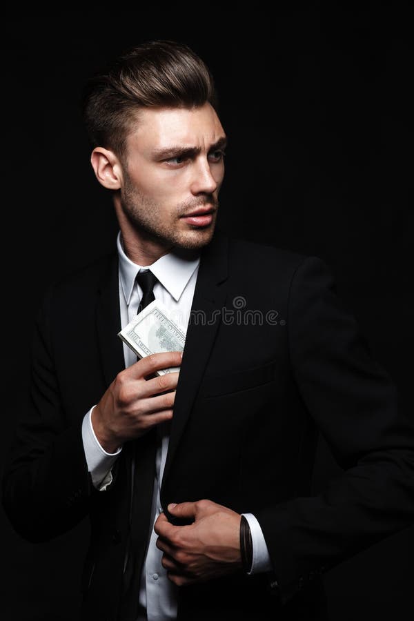 Handsome young man in suit on dark background with royalty free stock photo