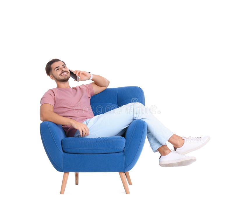 Handsome young man talking on phone in armchair