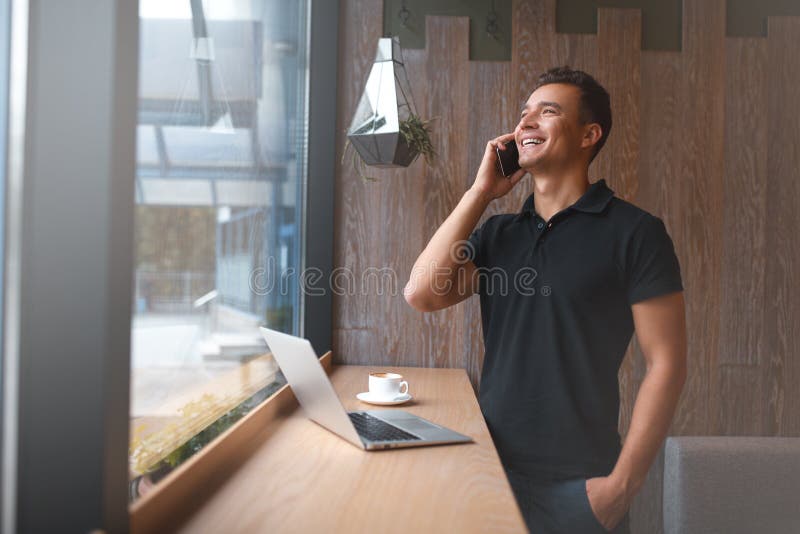 Handsome young man talking on phone and smiling