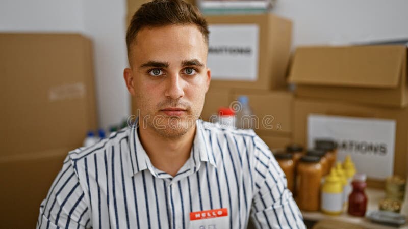 Handsome young man in a warehouse with cardboard boxes and moving supplies in the background royalty free stock photos