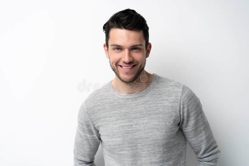 Handsome young man on white background looking at camera. Happy guy smiling