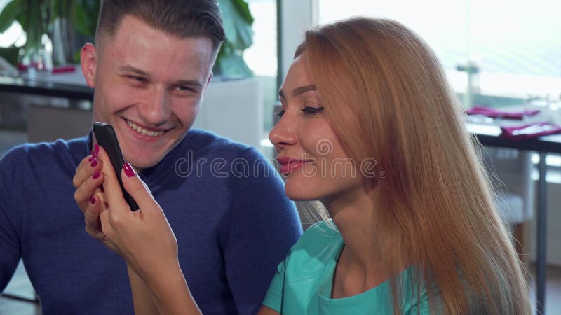 Handsome young man and his beautiful girlfriend using smart phone stock photos Handsome young man and his beautiful girlfriend using smart phone stock photos