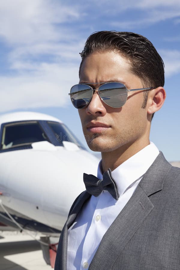 Handsome Young Men Wearing Sunglasses With Private Plane In Background