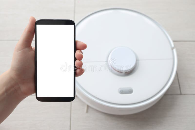 Handsteuerung des Roboter-Staubsaugers in der App auf dem Handybildschirm. Wohnungsreinigung lizenzfreie stockfotos