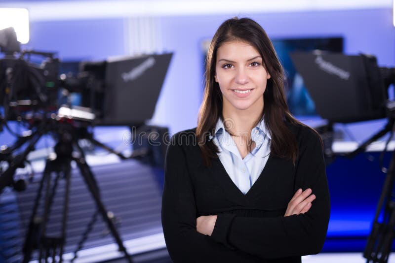 Handstil och anmäla för nyheterna Kvinnajournalist i televisionstudioanseende med hennes korsade armar royaltyfri bild Handstil och anmäla för nyheterna Kvinnajournalist i televisionstudioanseende med hennes korsade armar royaltyfri bild