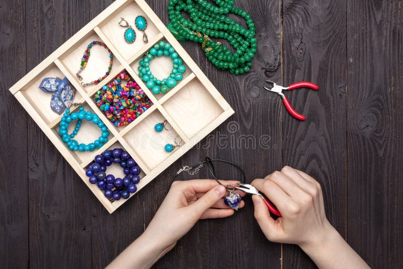 Handwork thuis, het meisje maakt juwelenhanden op de lijst stock foto Handwork thuis, het meisje maakt juwelenhanden op de lijst stock foto