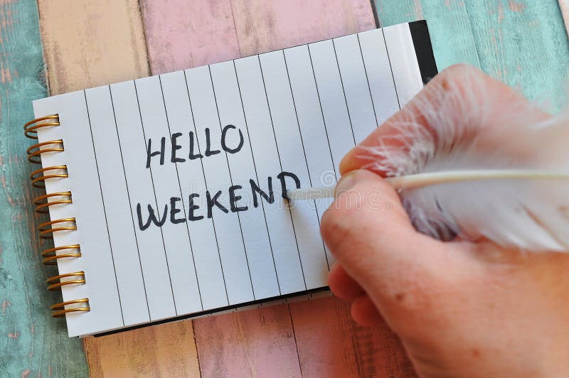 Handwritten hello weekend write. hello weekend write in notebook on old wood background