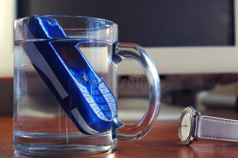 Handy im Glas des Wassers stockfotografie Handy im Glas des Wassers stockfotografie