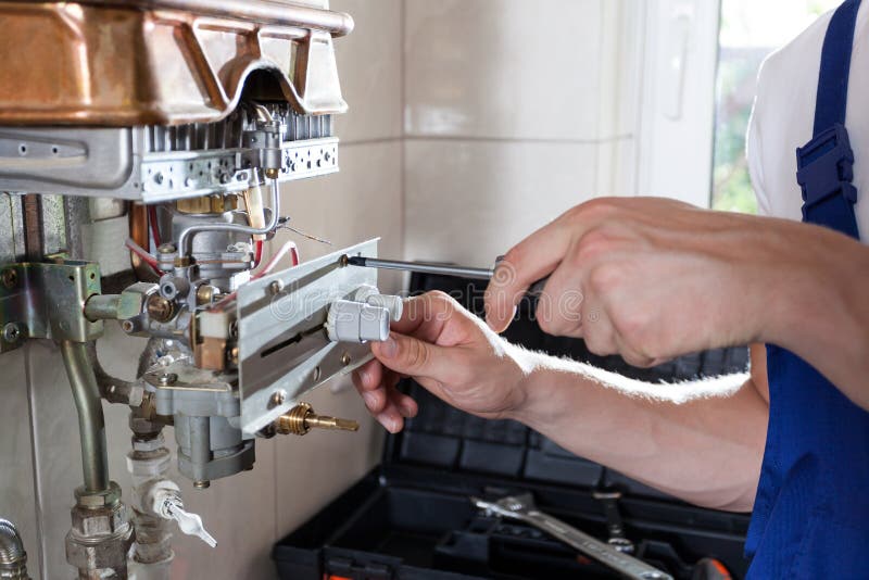 Handyman adjusting gas water heater royalty free stock photography Handyman adjusting gas water heater royalty free stock photography