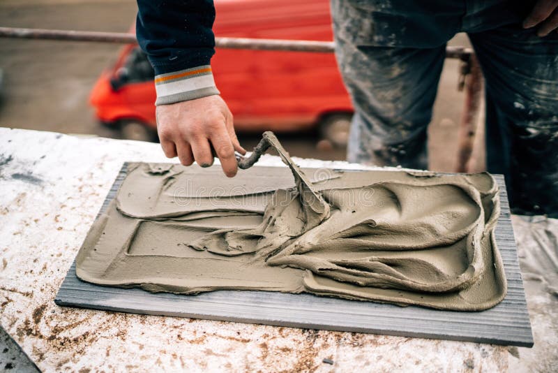 Close up of handyman fixing and applying ceramic tiles or marble stone on architecture facade. Bricklayer tiler stock images, royalty-free photos and pictures