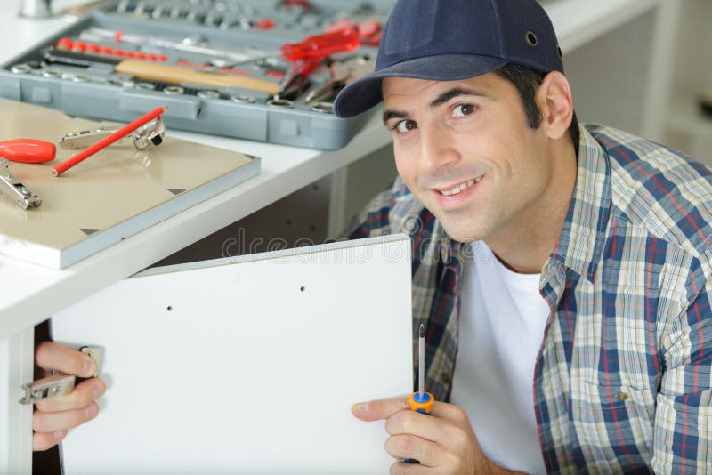 Handyman Fixing Door in Kitchen Cabinet Stock Image - Image of handyman
