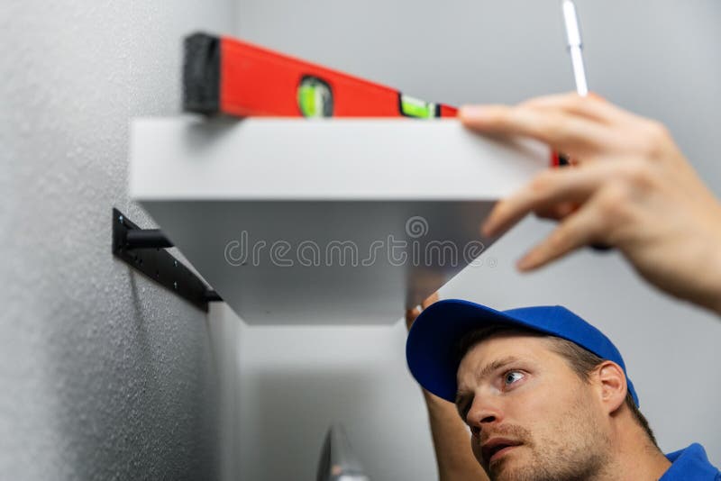 Handyman installing shelf on the wall at home stock photography Handyman installing shelf on the wall at home stock photography