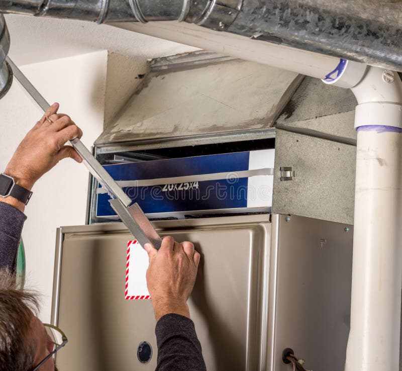 Handyman removes furnace pannel cover stock images Handyman removes furnace pannel cover stock images