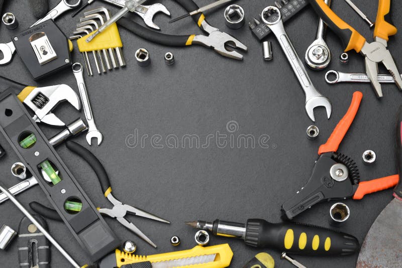 Handyman tool kit on black wooden table with copy space. Many wrenches and screwdrivers, pilers and other tools for any types of stock image