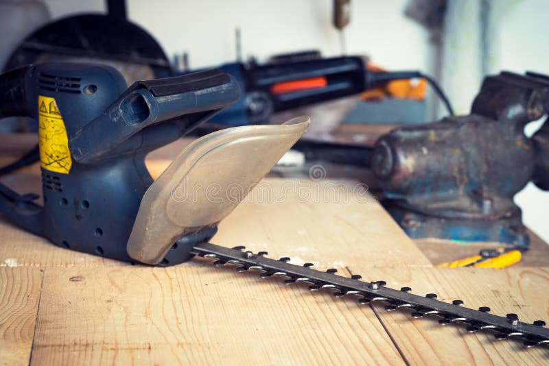 Handyman tool shed with hedge trimmer on the table royalty free stock photo