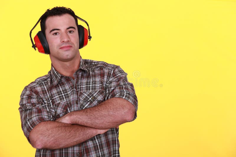 Handyman wearing ear muffs stock image. Image of builder 35737917