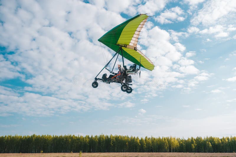 Hang Glider Pilot Makes Maneuvers Close To the Green Trees Stock Image