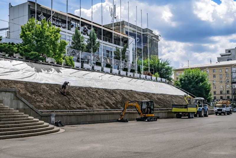 Hangbegrünung Arbeit auf einer Stadtstraße in charkow. Arbeiter beschäftigt sich mit Landschaftsgestaltung gegen lizenzfreie stockfotos