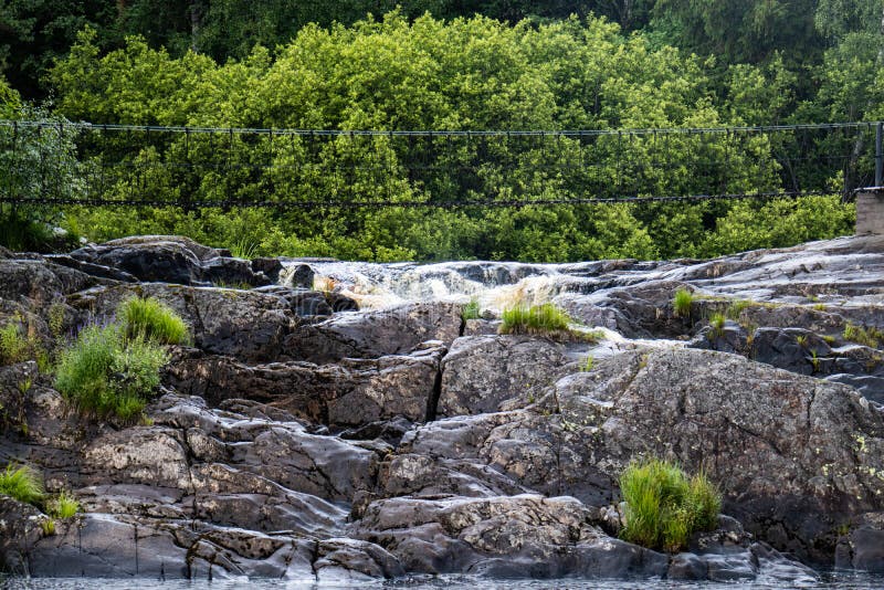 Hangbrug over een bergrivier met een waterval royalty-vrije stock fotografie Hangbrug over een bergrivier met een waterval royalty-vrije stock fotografie