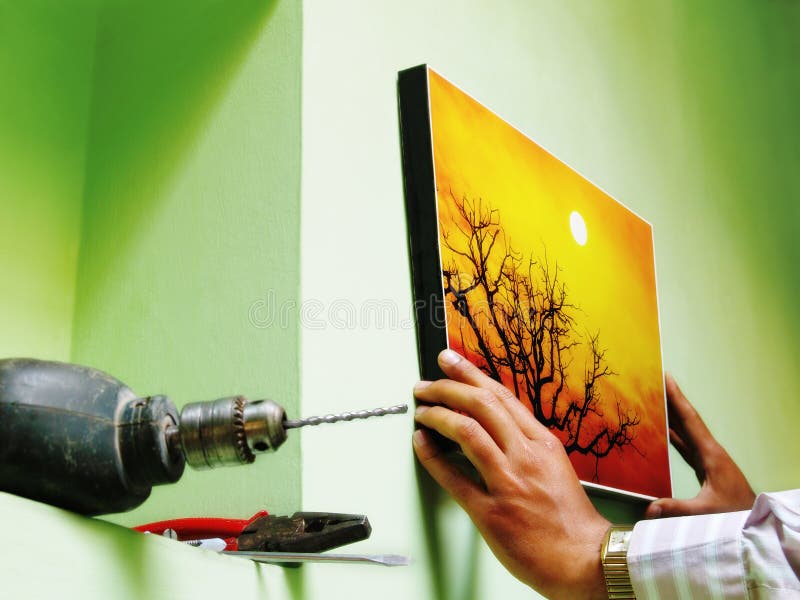 Hombre colgante una foto sobre el muro, herramientas Ellos son sobre el mano.