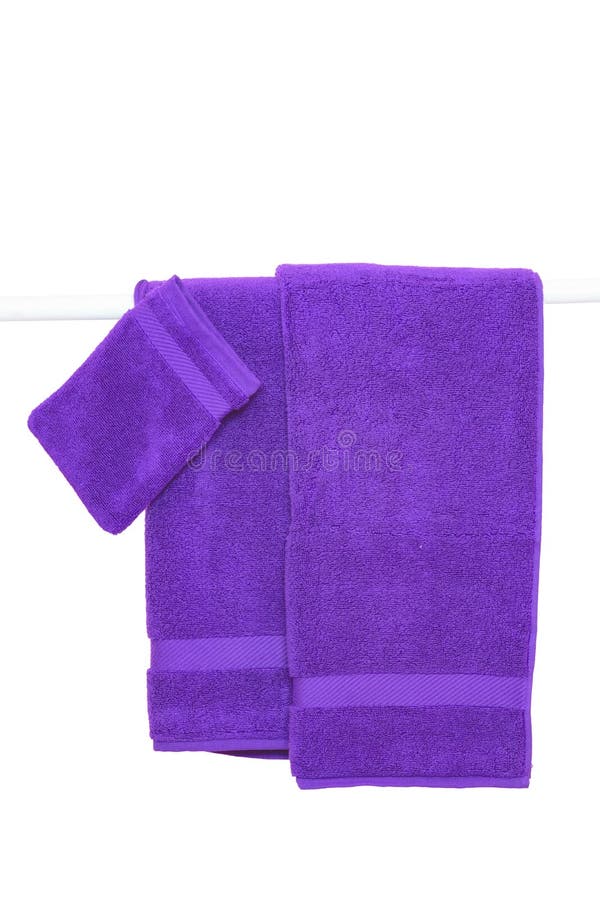 Hanging towels isolated. Closeup of purple soft terry bath towels hang on a clothes rail isolated on a white backgroun royalty free stock image