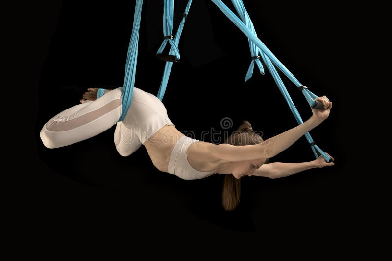 Hanging yoga hammock workout. Stretching the back muscles, inverted asana. Black background stock photos