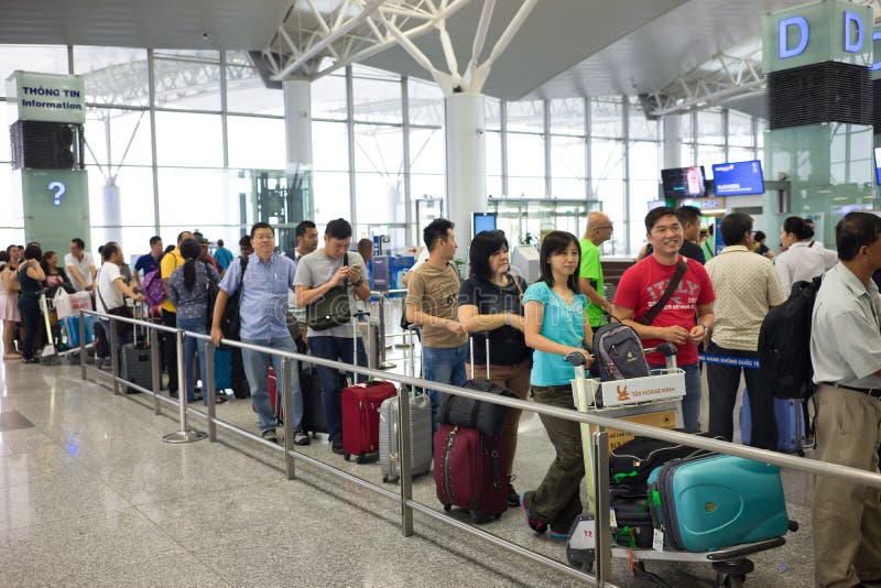 Hanoi, Vietnam - 29 aprile 2016: Coda della gente asiatica nella linea che aspetta al portone di imbarco nell'aeroporto di Noi Ba fotografie stock