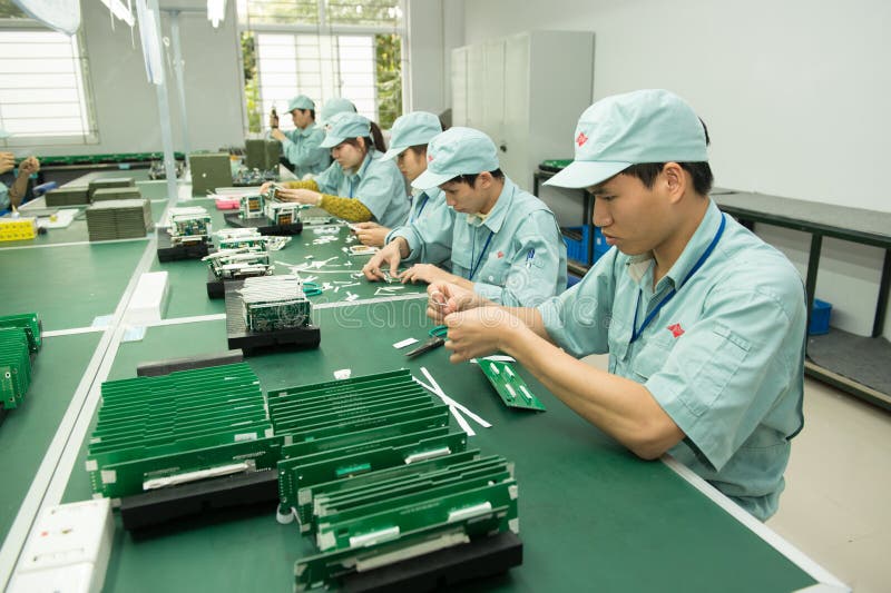 Hanoi Vietnam - Februari 13, 2015: Arbetare, i tillverkning av elektroniska delar i Vietnam arkivfoto Hanoi Vietnam - Februari 13, 2015: Arbetare, i tillverkning av elektroniska delar i Vietnam arkivfoto