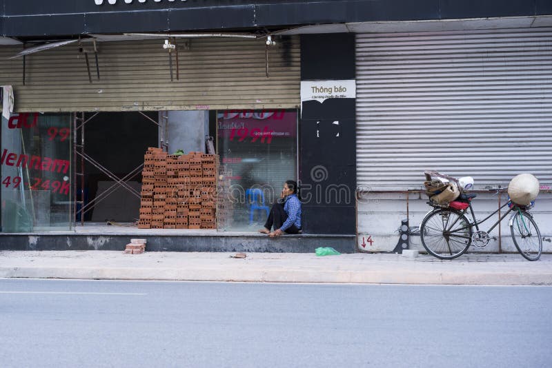 Hanoi, Vietnam May 25: Unidentified woman has cellphone talk in break time on street on May 25, 2014 in Hanoi, Vietnam stock photo Hanoi, Vietnam May 25: Unidentified woman has cellphone talk in break time on street on May 25, 2014 in Hanoi, Vietnam stock photo