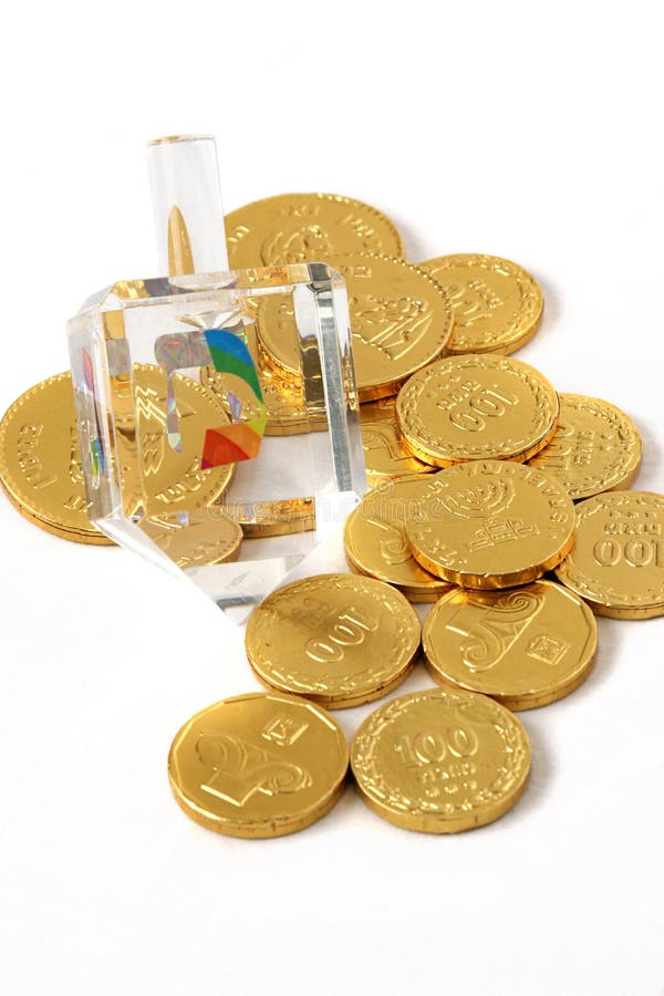 A fancy, crystal dreidel for Hanukah, along with chocolate coins (gelt). (trademarks removed, only hebrew symbols left). A fancy, crystal dreidel for Hanukah, along with chocolate coins (gelt). (trademarks removed, only hebrew symbols left)