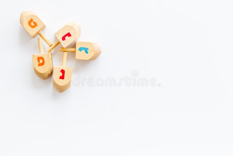 Hanukkah dreidels on white table. Jewish holideys concept. Top view. space for text stock photos Hanukkah dreidels on white table. Jewish holideys concept. Top view. space for text stock photos