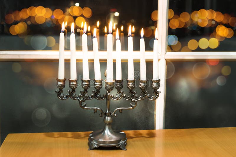 Hanukkah felice Immagine scura della festa ebrea Chanukah con menorah dalla finestra con la vista di notte sfuocato su Tel Aviv, immagini stock libere da diritti Hanukkah felice Immagine scura della festa ebrea Chanukah con menorah dalla finestra con la vista di notte sfuocato su Tel Aviv, immagini stock libere da diritti