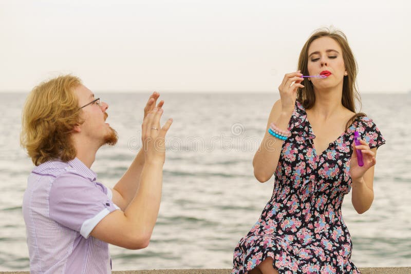 Couple playing with soap bubbles stock photography