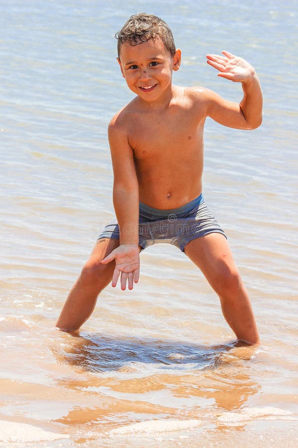 Liittle ragazzo è felice e gioca sulla spiaggia.