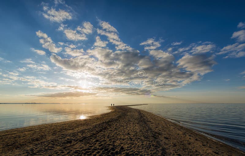 Two people walking toward the sea horizon. Serene beach atmosphere stock images, royalty-free photos and pictures