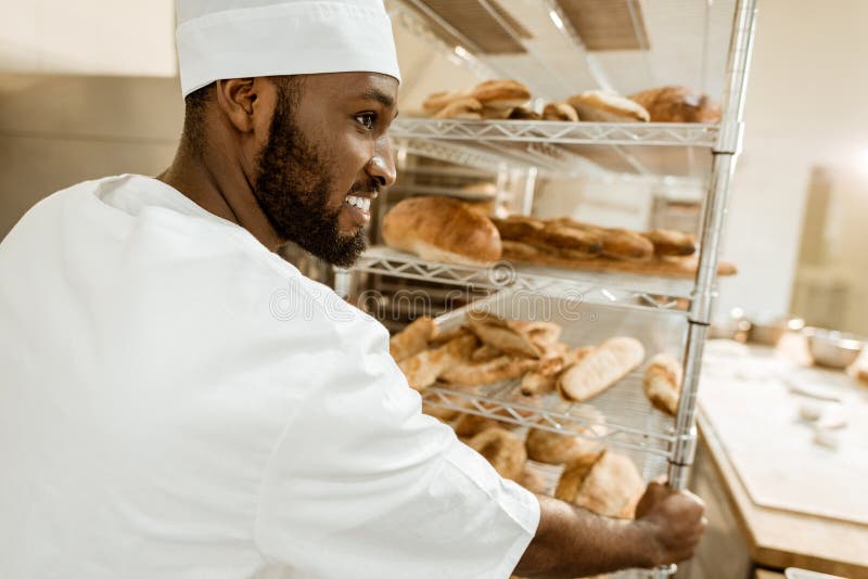 happy african american baker driving shelves of fresh bread royalty free stock photo happy african american baker driving shelves of fresh bread royalty free stock photo