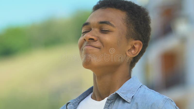 Happy african-american boy breathing enjoying fresh air, outdoor walk closeup