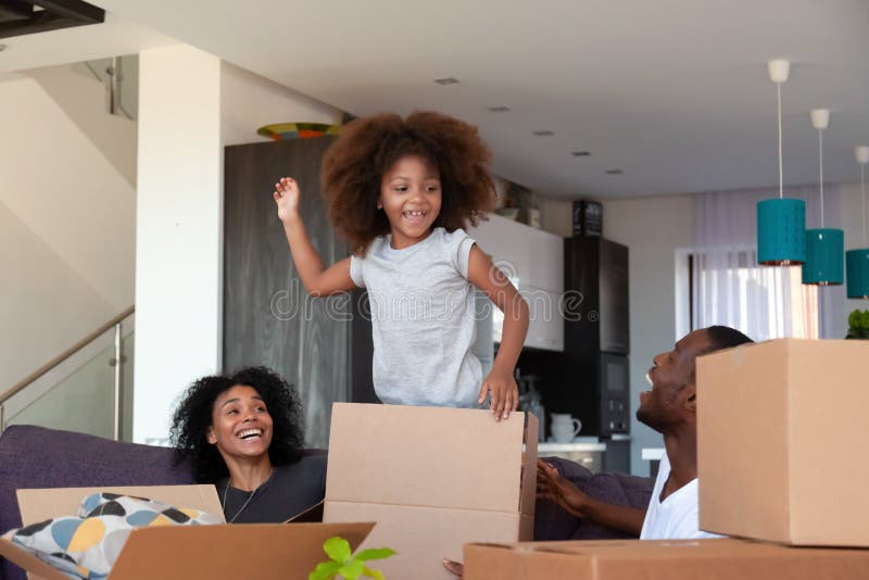 Happy African American child and parents unpacking boxes in new house stock images Happy African American child and parents unpacking boxes in new house stock images