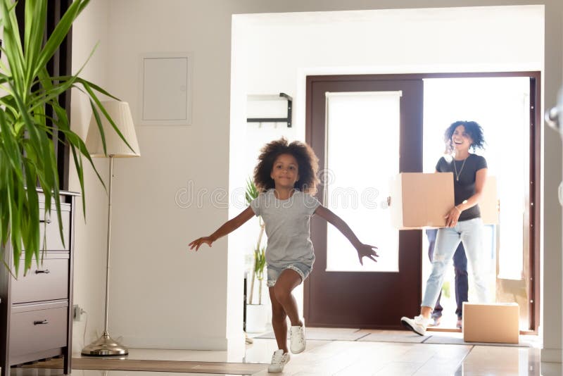 Happy African American family with cardboard boxes in new home